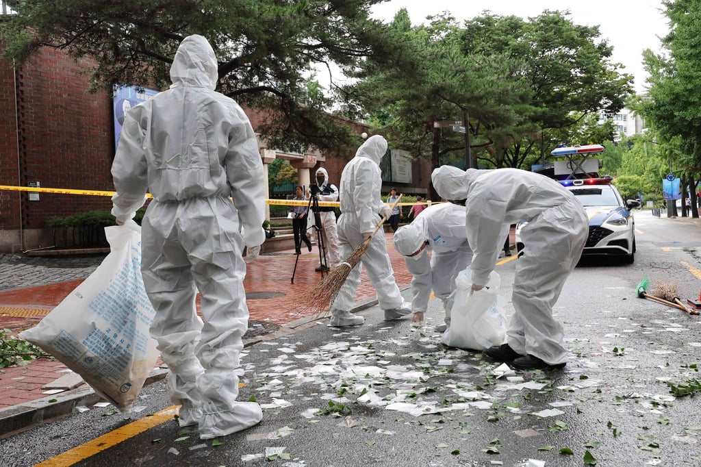 South Korean officials clean up the contents of a trash-carrying balloon on a street in Seoul. Photo: AFP