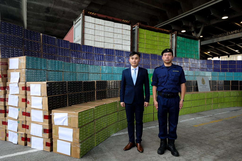 (From left) Lam Wai-kit and Lam Ming-hong of Hong Kong Customs with the 30.4 million black market cigarettes impounded after a sea chase of a cargo ship. Photo: Xiaomei Chen