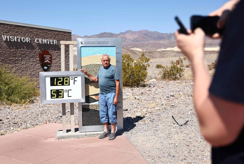 A tourist poses next to an unofficial thermometer at Furnace Creek Visitor Centre in Death Valley National Park on July 9. Photo: AFP