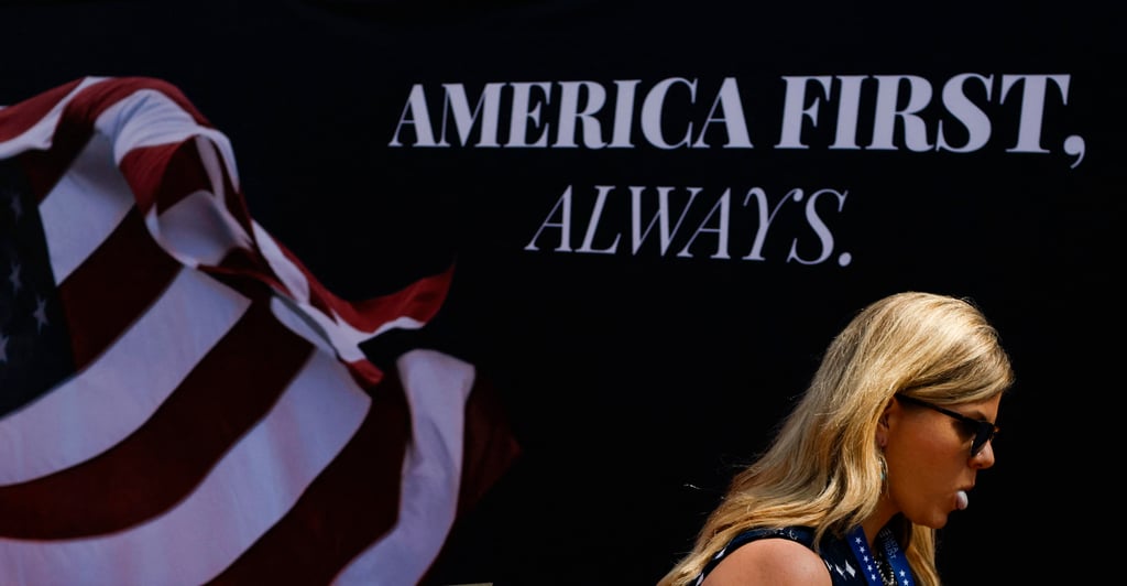 A woman walks past an “America First” sign at the Republican National Convention on July 18. Trump’s first term was marked by protectionist tendencies. Photo: Reuters