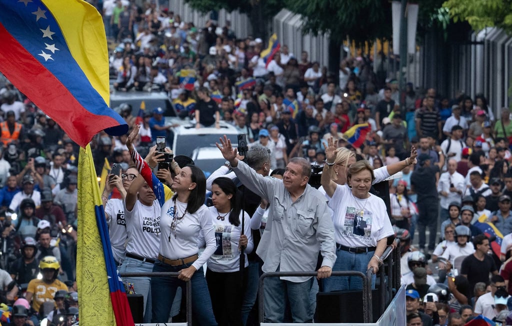 Venezuelan opposition leader Maria Corina Machado waves next to opposition presidential candidate Edmundo Gonzalez Urrutia. Photo: AFP