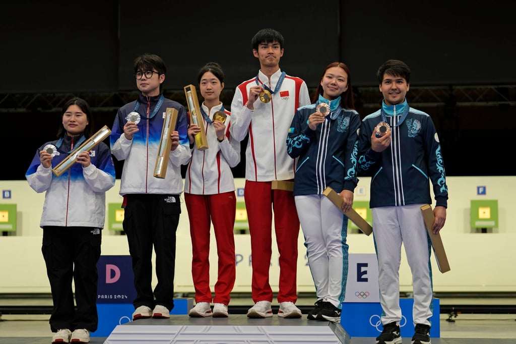 China’s Huang Yuting (centre left) and Sheng Lihao (centre right) stand on the podium after securing Paris Olympic Games gold medals. Photo: AP