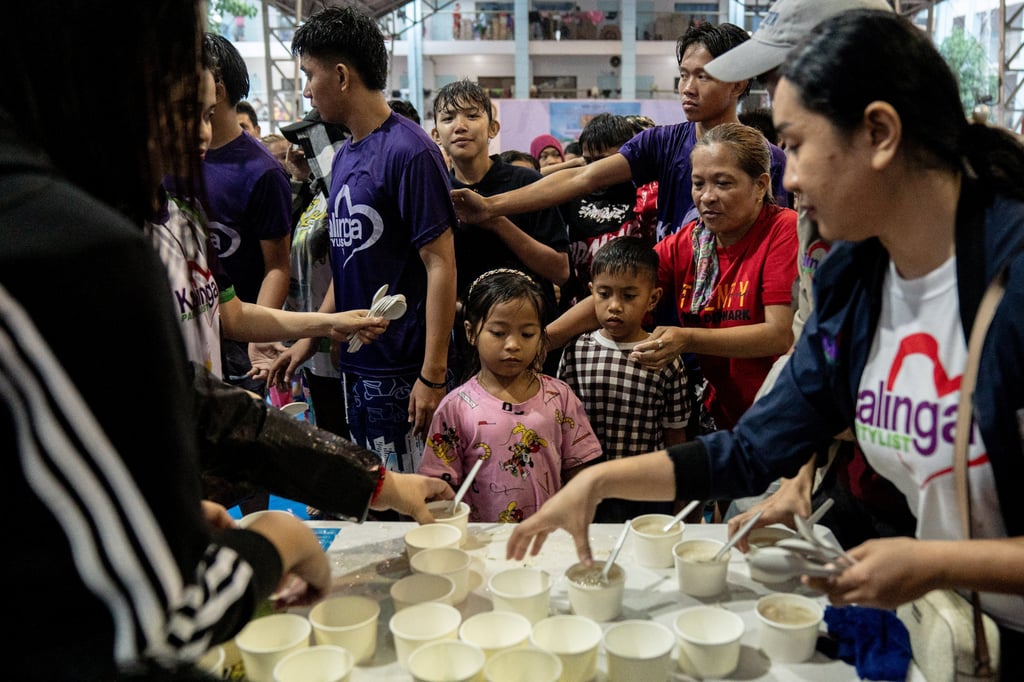 People queue for food in a school temporarily converted into an evacuation centre in the Philippines as Typhoon Gaemi ravages parts of the country. Photo: Reuters