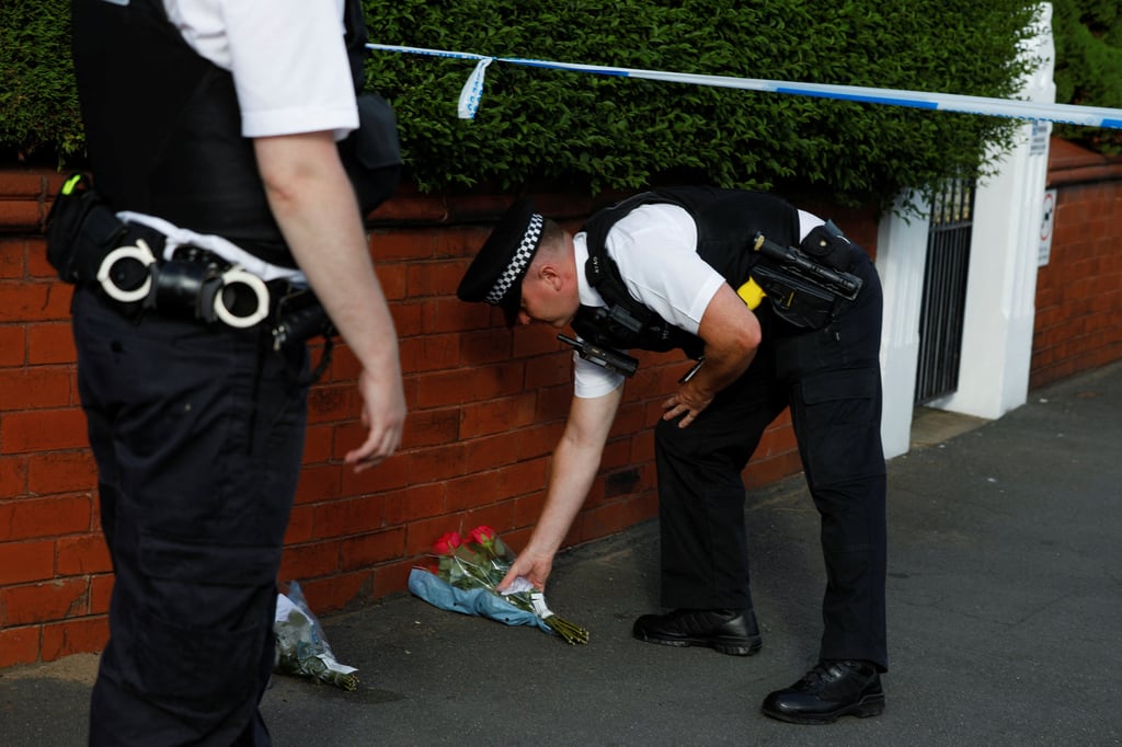 A police officer places flowers, given by residents, near the scene of the stabbing incident. Photo: Reuters A police officer places flowers, given by residents, near the scene of the stabbing incident. Photo: Reuters