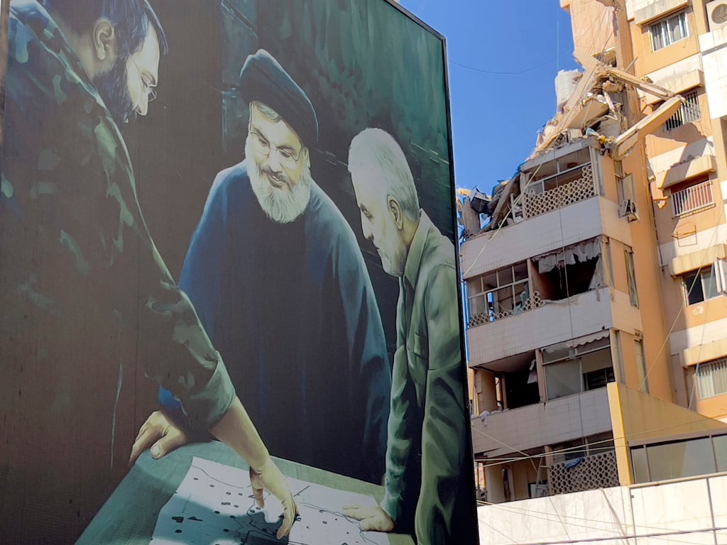 A poster showing the late Hezbollah military commander Imad Mughniyeh, left, Hezbollah leader Sayyed Hassan Nasrallah, centre, and the late Revolutionary Guard General Qassem Soleimani near a damaged building that was hit by an Israeli air strike in Beirut. Photo: AP