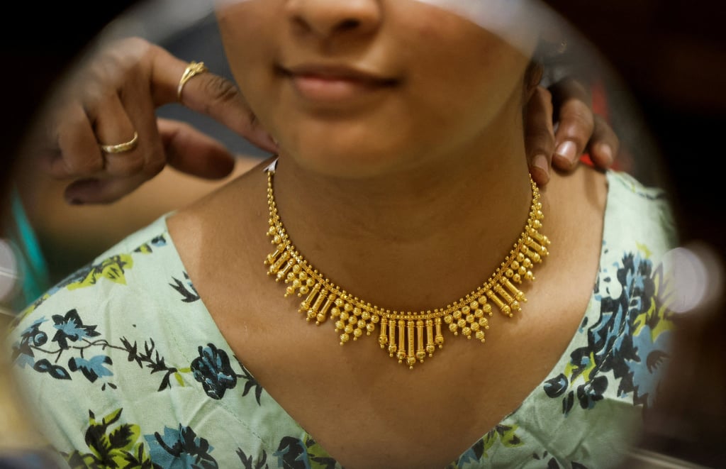 A woman tries on a gold necklace at a jewellery showroom during Dhanteras, a Hindu festival associated with Lakshmi, the goddess of wealth, in Mumbai, India, in November 2023. Photo: Reuters