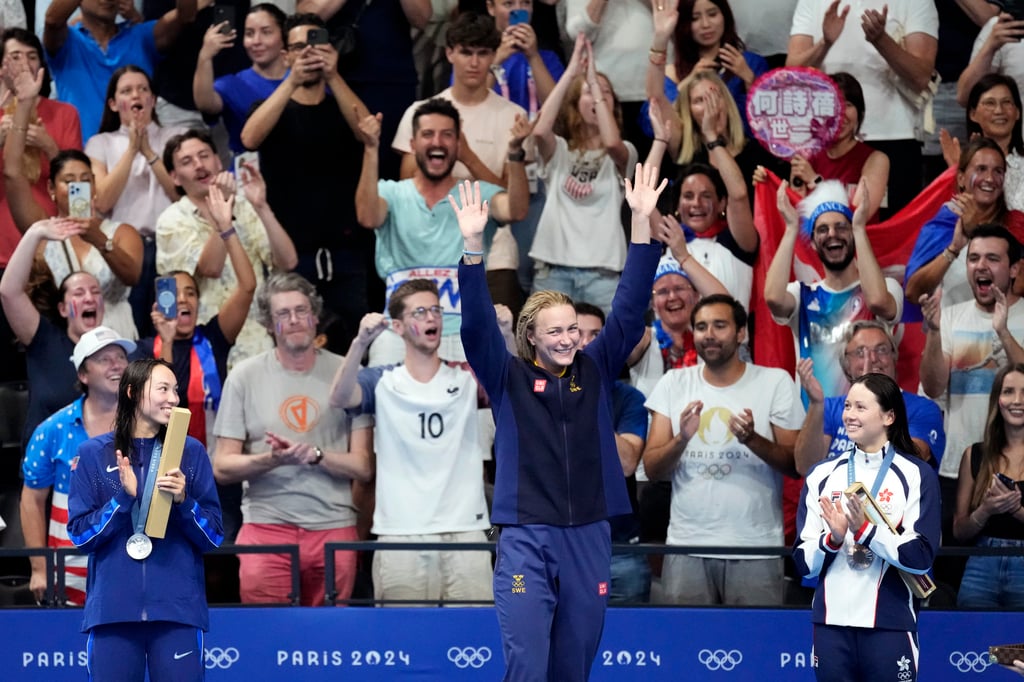 Winner Sarah Sjostrom (centre) is applauded on to the podium by Siobhan Haughey (right). Photo: AP