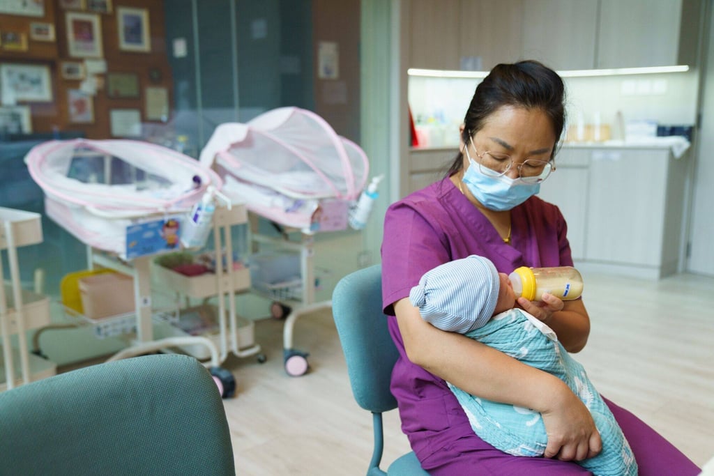 An employer feeds a baby at the My Queen confinement centre in Singapore. Photo: Bloomberg