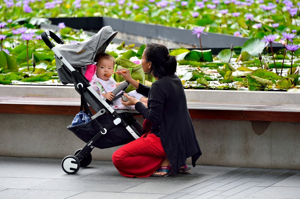 A mother feeding her baby in a park in Singapore. Photo: Shutterstock