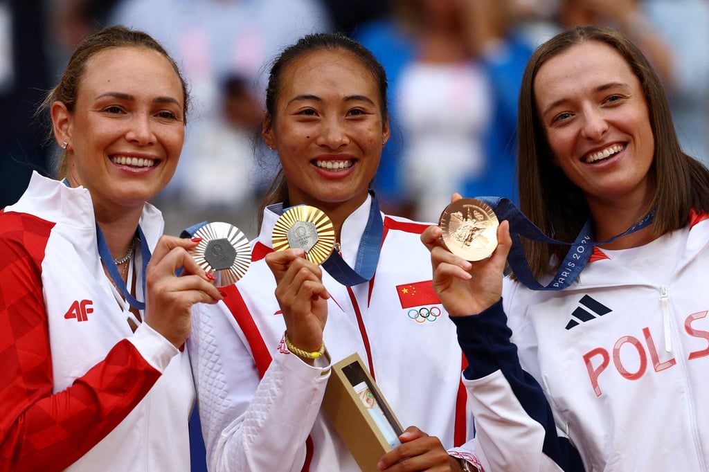 Qinwen Zheng (centre) shows off her gold medal alongside sliver medallist Donna Vekic (left) and Iga Swiatek, who won bronze. Photo: Reuters