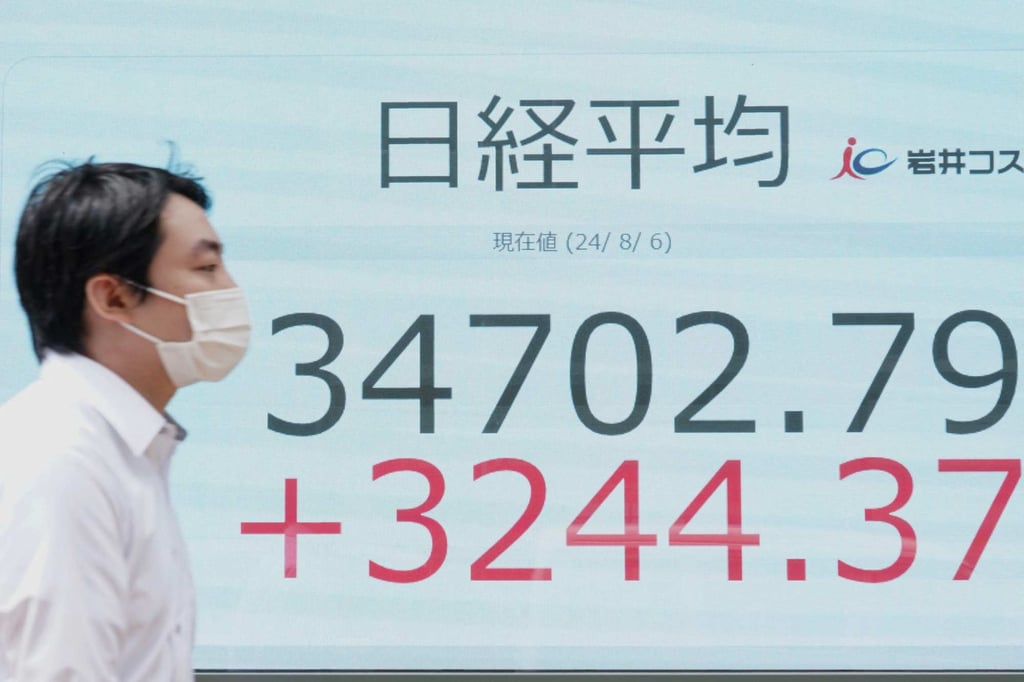 A man walks in front of an electronic board displaying the Nikkei 225 Index on August 6. Photo: AFP A man walks in front of an electronic board displaying the Nikkei 225 Index on August 6. Photo: AFP