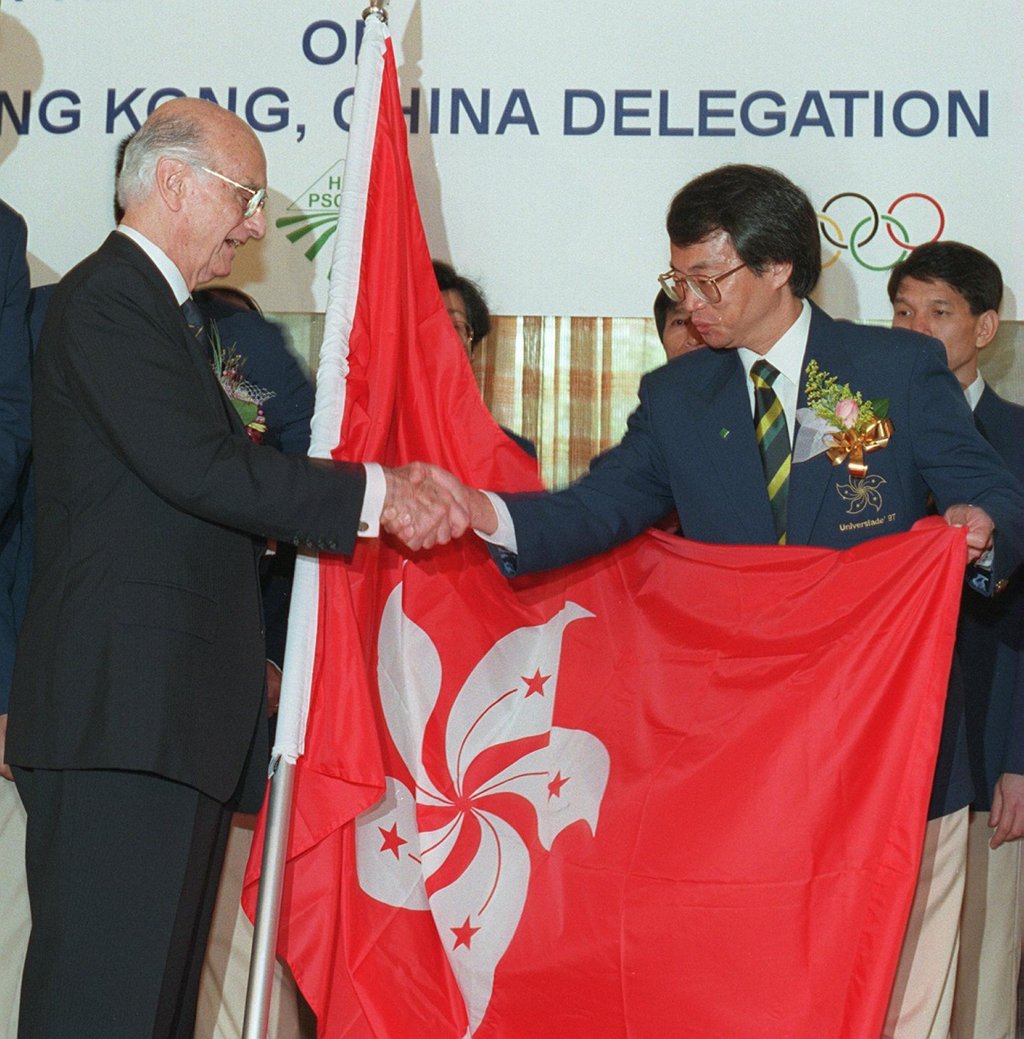 A de O’Sales, former president of the Hong Kong Amateur Sports Federation and Olympic Committee, presents the SAR flag to Kenny Chow Kun-wah, deputy head of the Hong Kong delegation to Sicily, Italy, in preparation for the 1997 University Games. Photo: SCMP A de O’Sales, former president of the Hong Kong Amateur Sports Federation and Olympic Committee, presents the SAR flag to Kenny Chow Kun-wah, deputy head of the Hong Kong delegation to Sicily, Italy, in preparation for the 1997 University Games. Photo: SCMP