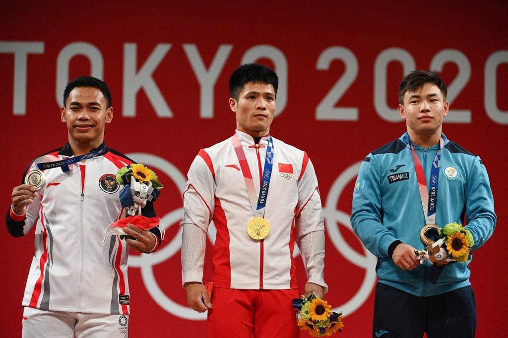 China’s Li Fabin (centre) will be looking to defend his men’s 61kg weightlifting gold medal in Paris. Photo: AFP