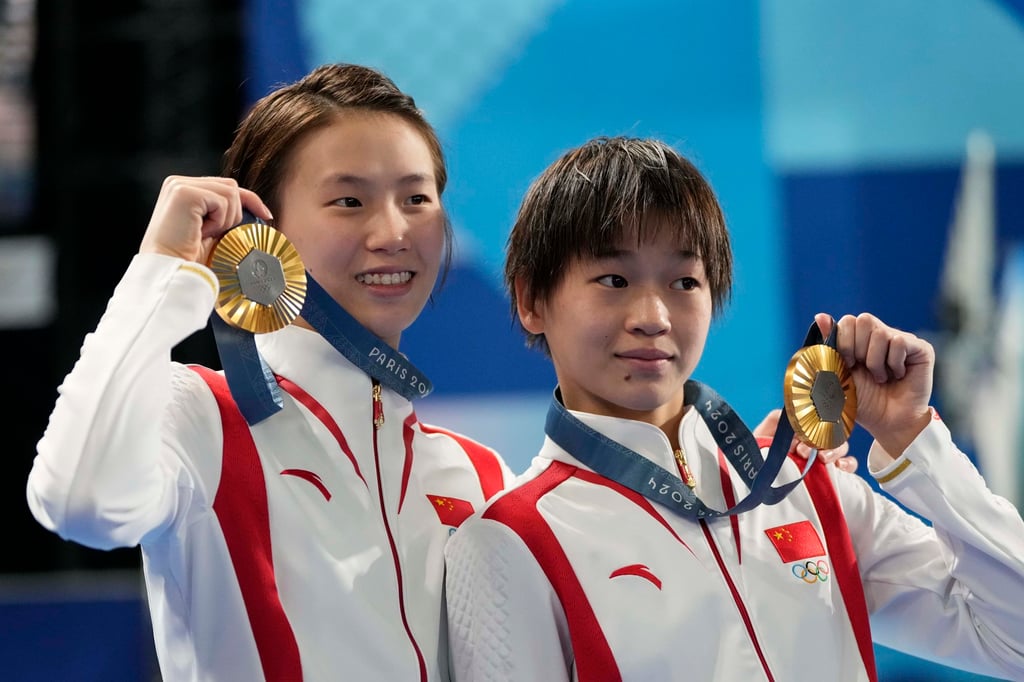 Quan Hongchan (right) and teammate Chen Yuxi show off their women’s synchronised 10m diving gold medals. Photo: AP