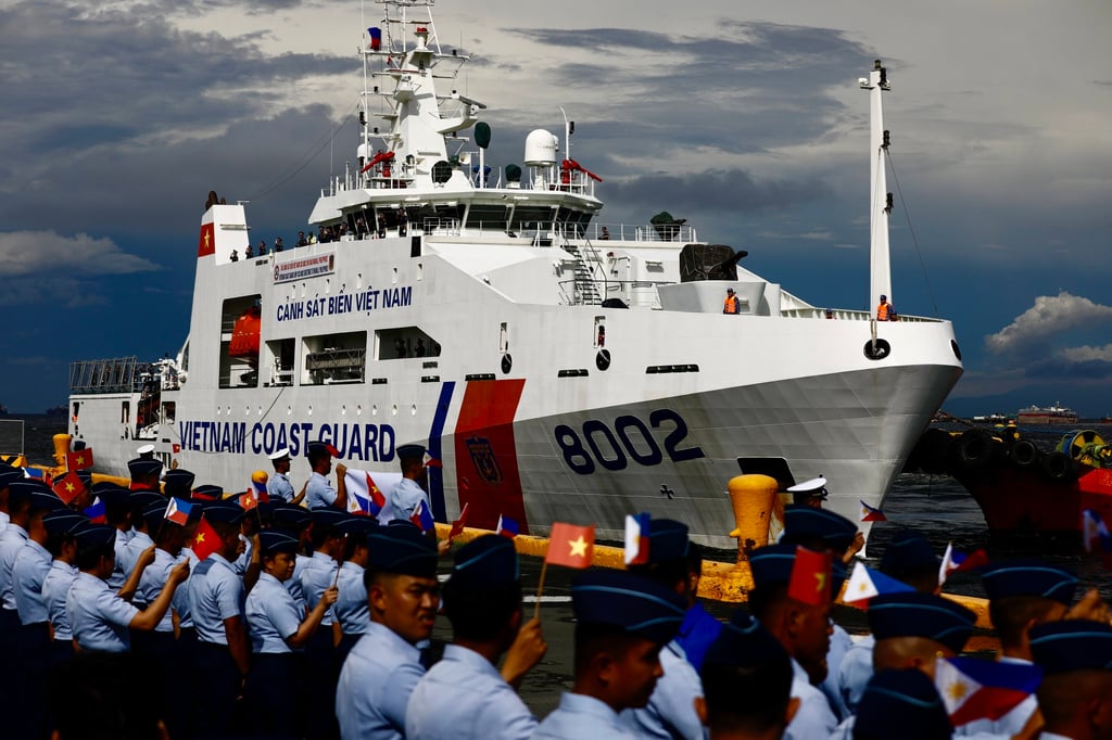 Philippine Coast Guard personnel wave flags as the Vietnam Coast Guard CSB-8002 patrol ship makes a port call at the Port of Manila on August 5. Photo: EPA-EFE