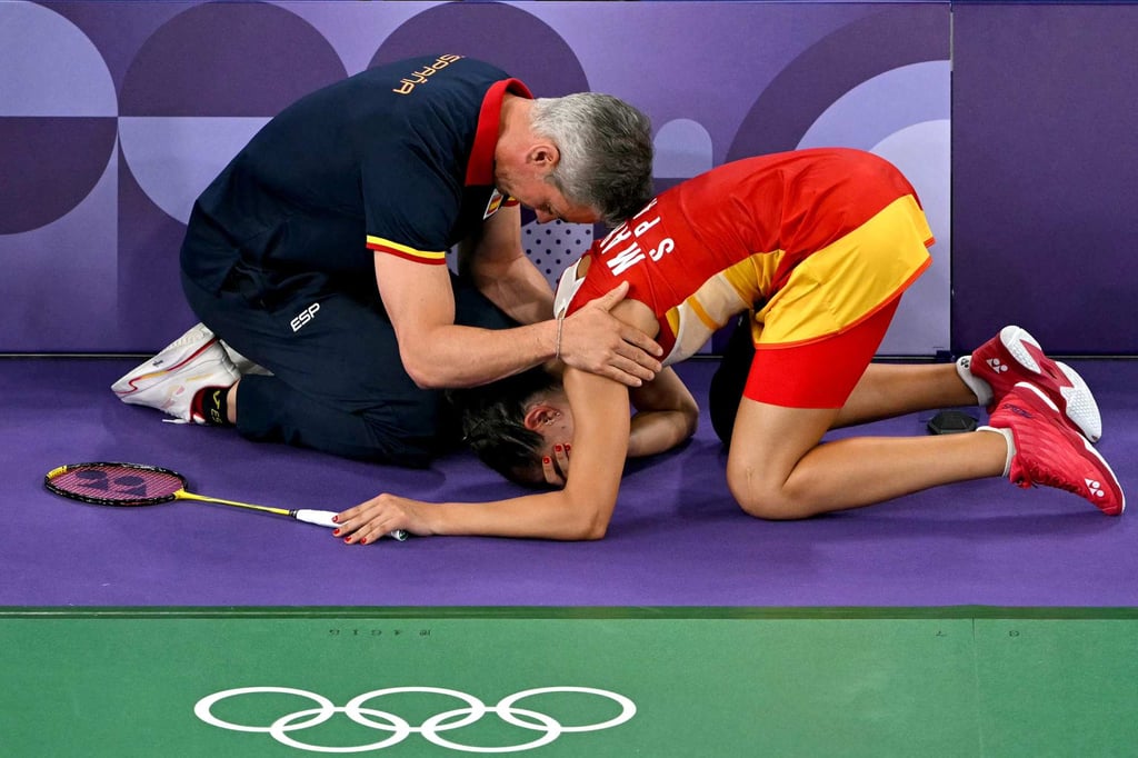 Spain’s Carolina Marin is comforted by her coach Fernando Rivas after conceding her women’s singles badminton semi-final against China’s He Bingjiao. Photo: AFP