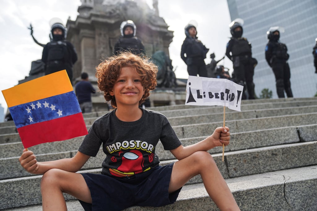 A child holds a Venezuelan flag and a sign that reads “freedom” as people march to protest against election results that awarded Venezuela’s President Nicolas Maduro a third term, in Mexico City, Mexico on Saturday. Photo: Reuters