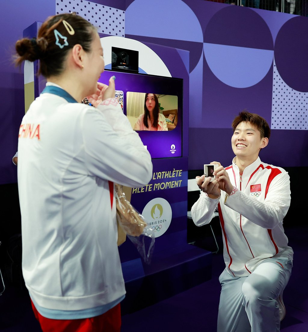 Chinese badminton player Liu Yuchen (right) gets down on one knee for Huang Yaqiong. Photo: Xinhua