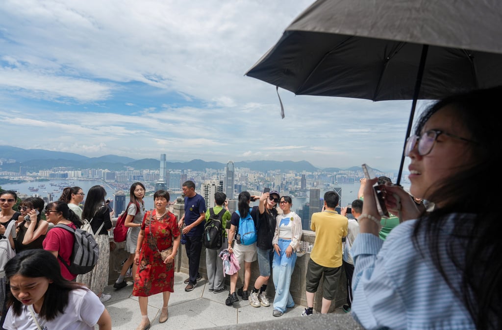 Tourists take in Hong Kong’s skyline at The Peak. Photo: Eugene Lee