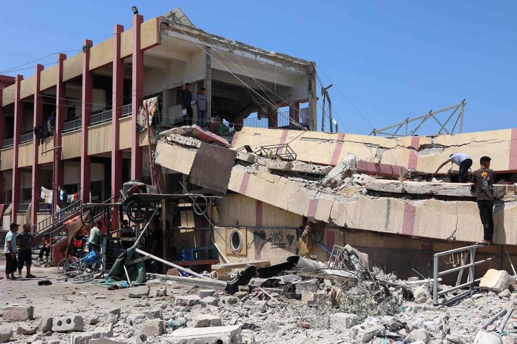 People inspect the damage after an Israeli strike on a school, housing displaced Palestinians, in central Gaza City on August 20. Photo: AFP