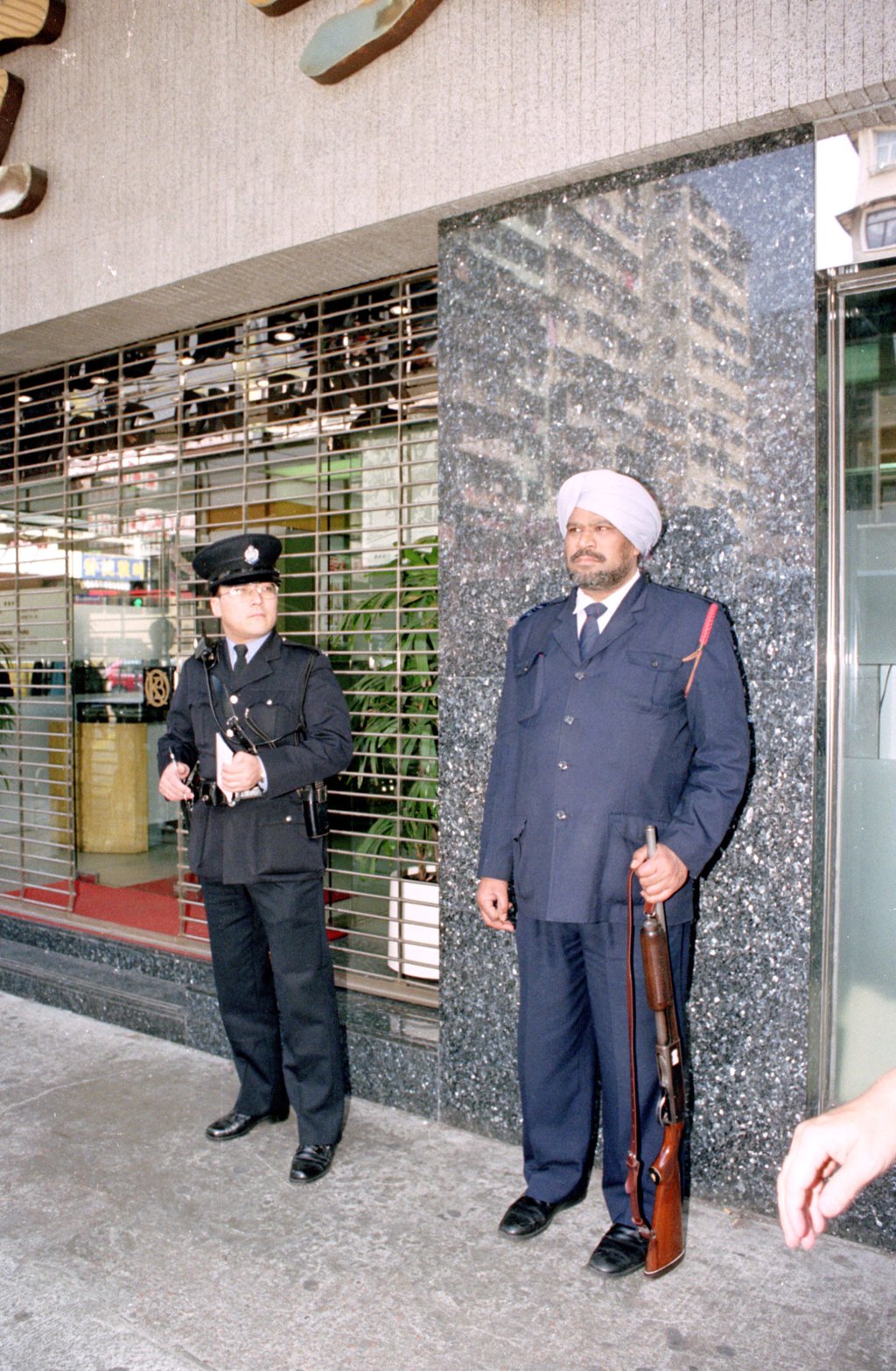 In 1995, a policeman stands beside a Sikh security guard outside the Sham Shui Po branch of Kwong On Bank, where a robbery had recently taken place. Photo: SCMP