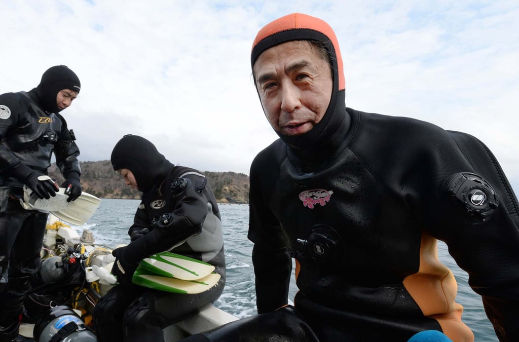 Yasuo Takamatsu, right, learned how to dive so he could keep looking for his wife. Photo: AFP