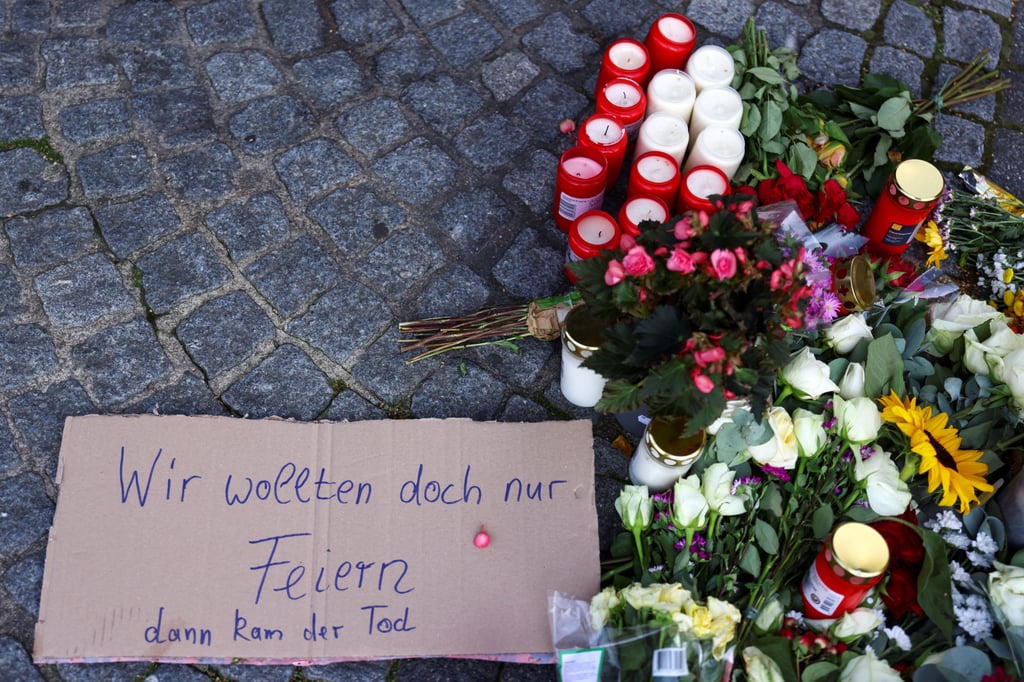 A sign that reads “We just wanted to celebrate, but then the death came” is placed next to flowers and candles on Saturday after the fatal attack in Solingen. Photo: Reuters