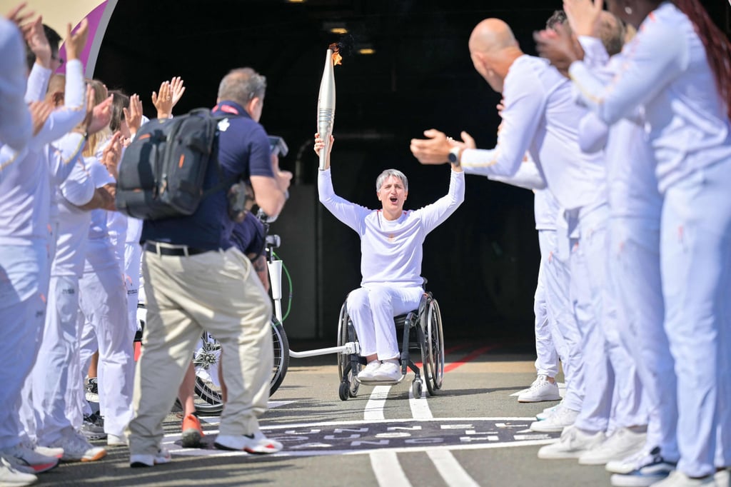 Wheelchair fencing medallist Emmanuelle Assmann holds the Paralympics torch after it was lit in the UK, at the entrance of the Channel Tunnel in Coquelles, northern France on Sunday. Photo: AFP