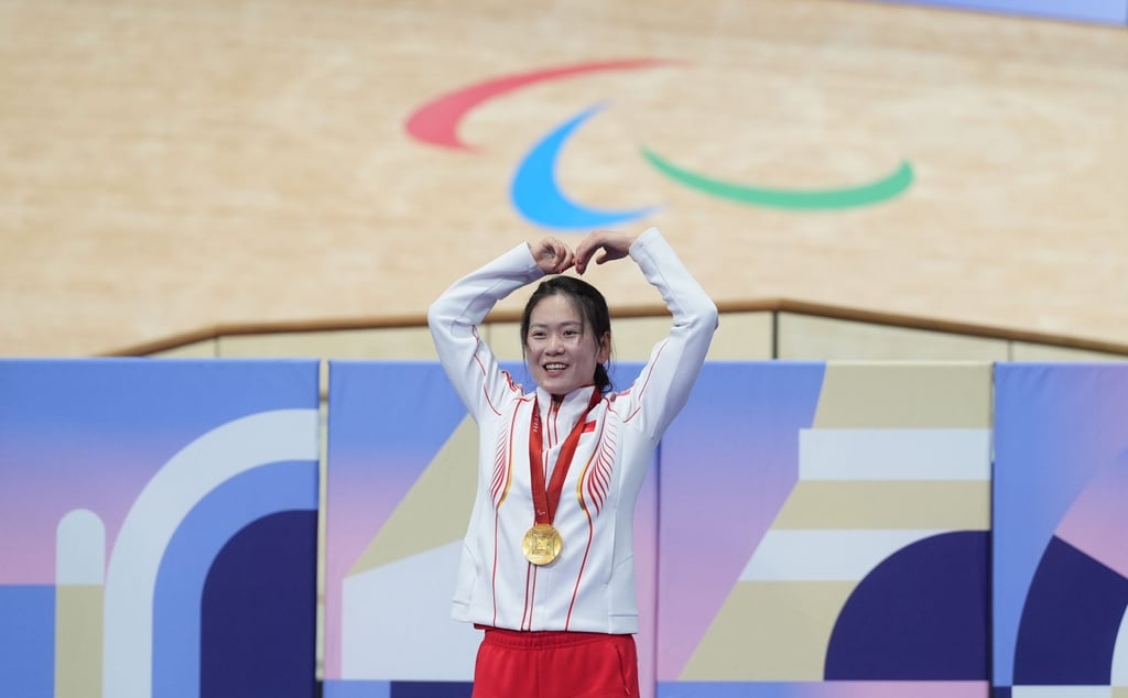 Wang Xiaomei celebrates atop the podium after winning gold in the women’s C1-3 3,000m individual pursuit. Photo: Xinhua