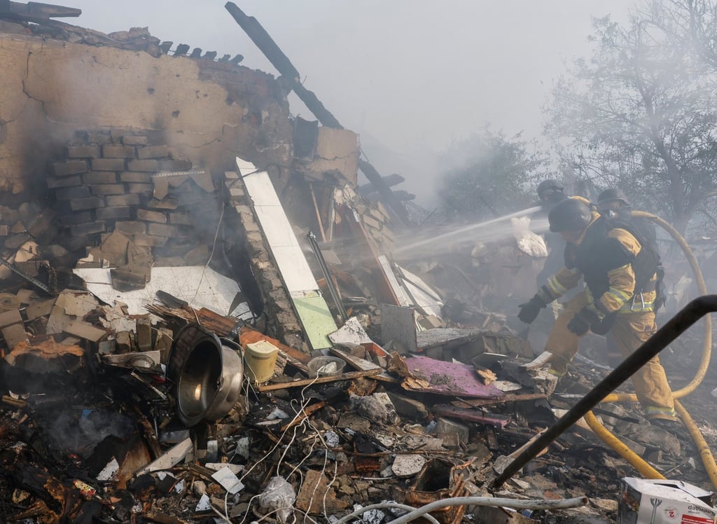 Ukrainian rescuers work at the site of a missile strike in Cherkaska Lozova, in the Kharkiv region, on Saturday. Photo: EPA-EFE