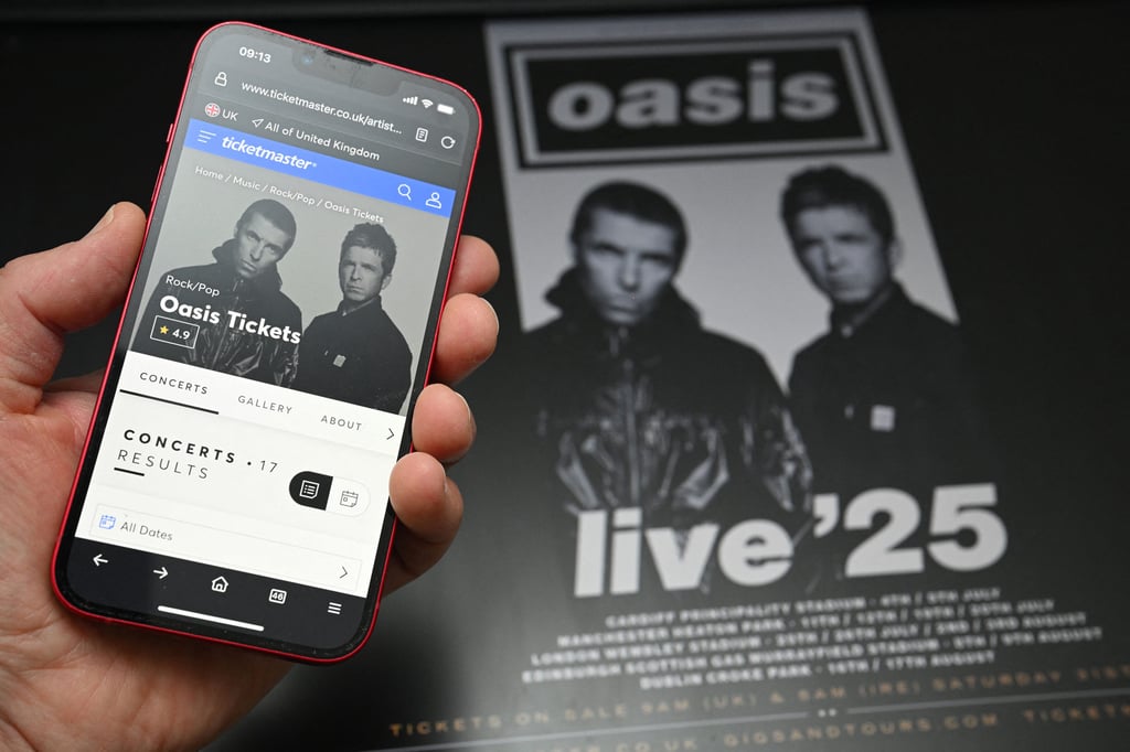 A fan in England uses a smartphone to access an online ticket sales website to buy tickets for Oasis’ 2025 tour. Photo: AFP / Getty Images / TNS A fan in England uses a smartphone to access an online ticket sales website to buy tickets for Oasis’ 2025 tour. Photo: AFP / Getty Images / TNS