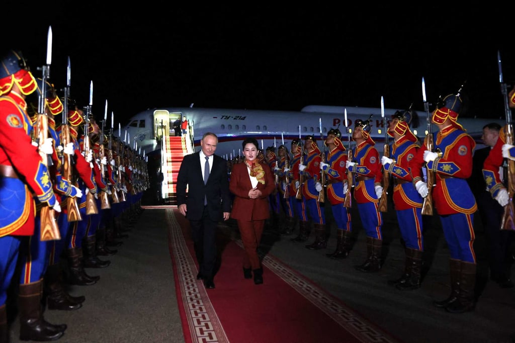 Russia’s President Vladimir Putin, accompanied by Battsetseg Batmunkh, Mongolia’s minister of foreign affairs, walks past honour guards upon arrival at the airport in Ulaanbaatar, Mongolia on Monday. Photo: AFP