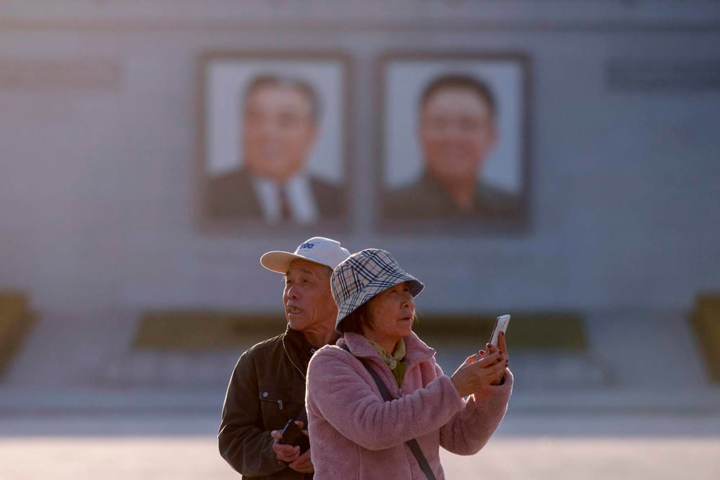 Chinese tourists take photos as they stand on Kim Il-sung square in Pyongyang in 2019. Photo: AFP