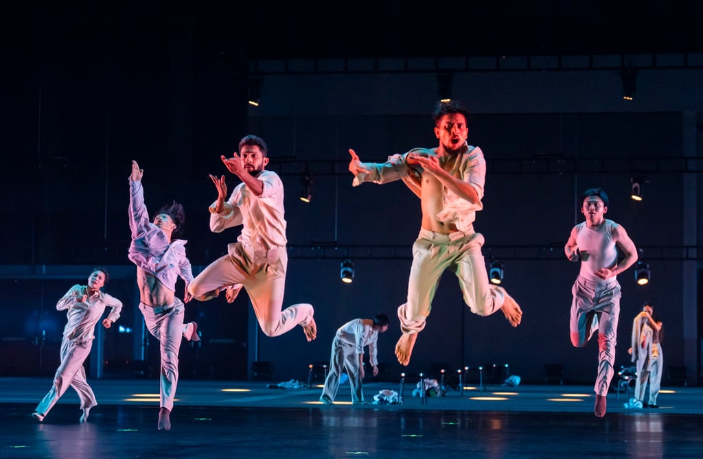 Dancers initially emerge as accountants wearing identical outfits and wigs, but later divide into two separate groups during the show. Photo: Tristram Kenton