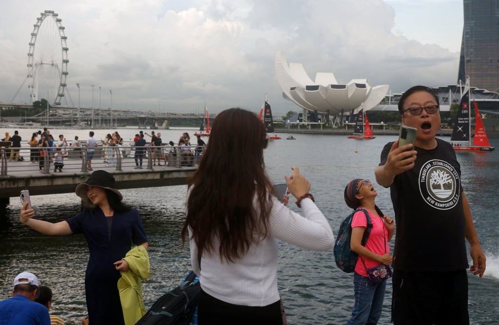 Chinese tourists pose for photos at Marina Bay in Singapore last year. Photo: Reuters Chinese tourists pose for photos at Marina Bay in Singapore last year. Photo: Reuters