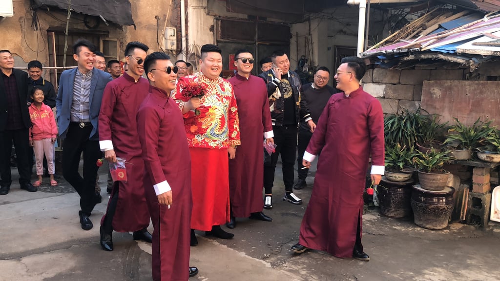 A groom in traditional dress surrounded by his groomsmen at a Chinese wedding. Photo: Shutterstock