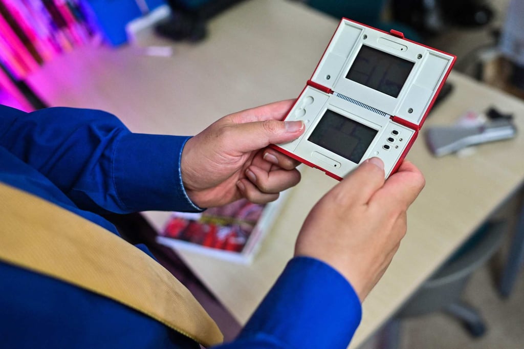 Video game historian and game history book author and publisher Hiroyuki Maeda with a prototype of a handheld Nintendo game at his office in Tokyo. Photo: AFP