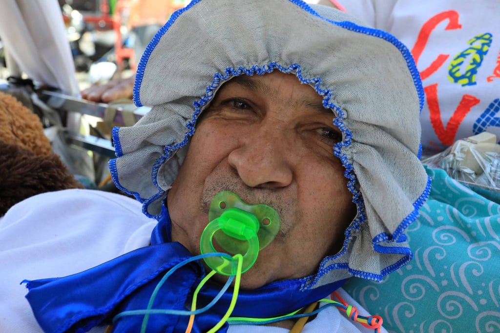 Seorang pria berpakaian seperti bayi dan dengan dot di mulutnya berpose saat perayaan Hari Kemalasan Sedunia di Kolombia. Foto: AFP