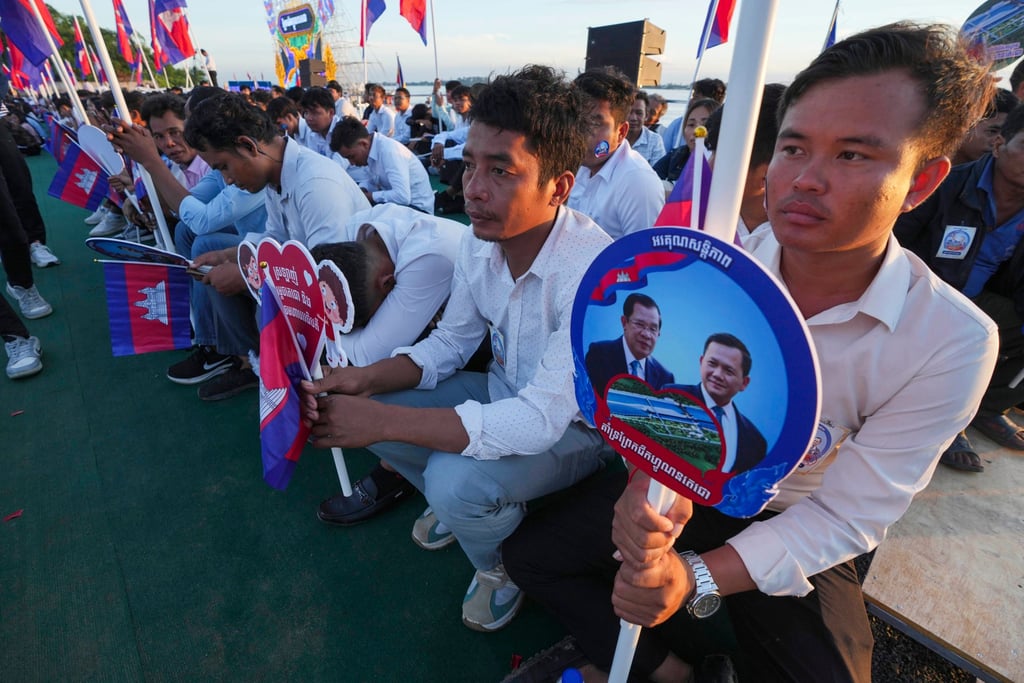 Civil servants hold photographs of Hun Manet and his father Hun Sen during a groundbreaking ceremony for the China-funded Funan Techo Canal project in August. Photo: AP