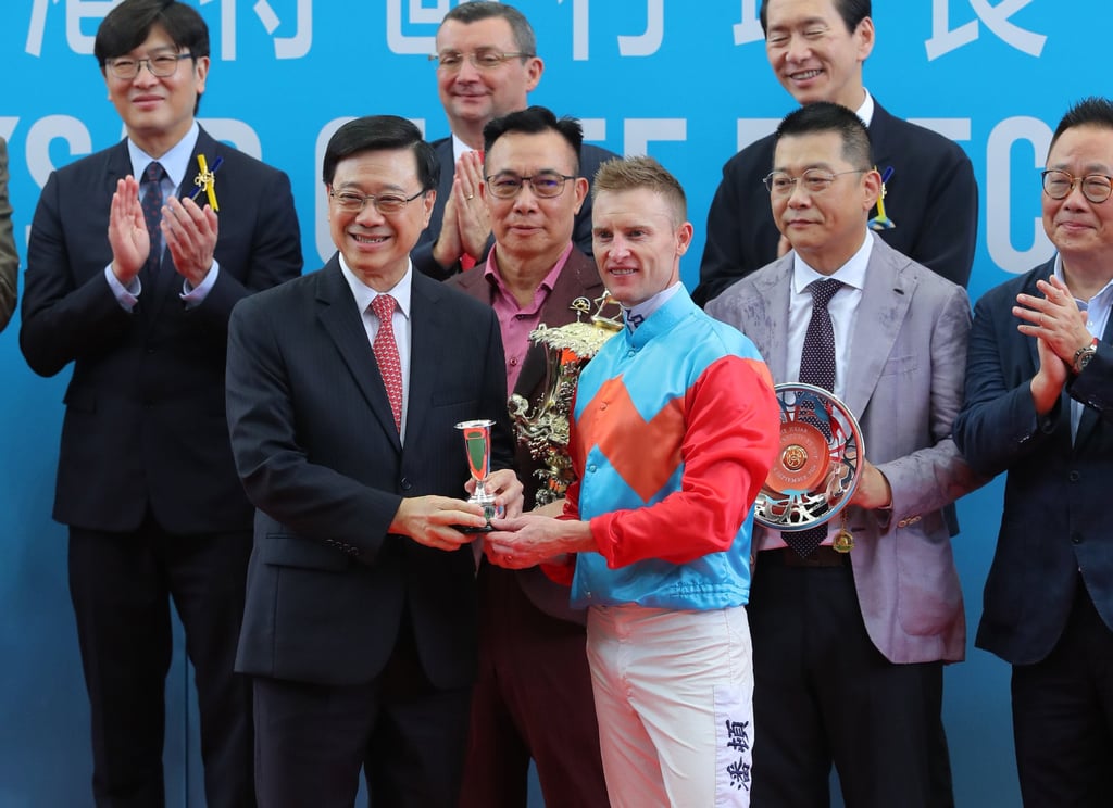 John Lee presents jockey Zac Purton with his Class One HKSAR Chief Executive’s Cup (1,200m) spoils. Photo: Kenneth Chan John Lee presents jockey Zac Purton with his Class One HKSAR Chief Executive’s Cup (1,200m) spoils. Photo: Kenneth Chan