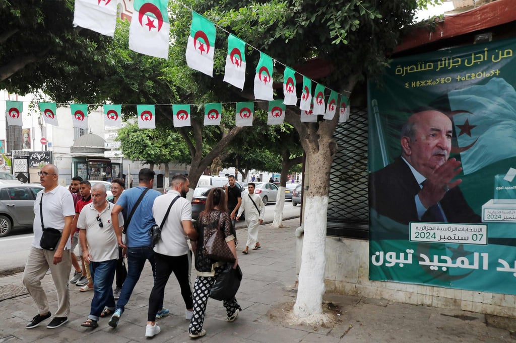 People walk past posters of Tebboune outside an election campaign headquarters in Algiers on Sunday. Photo: AFP People walk past posters of Tebboune outside an election campaign headquarters in Algiers on Sunday. Photo: AFP