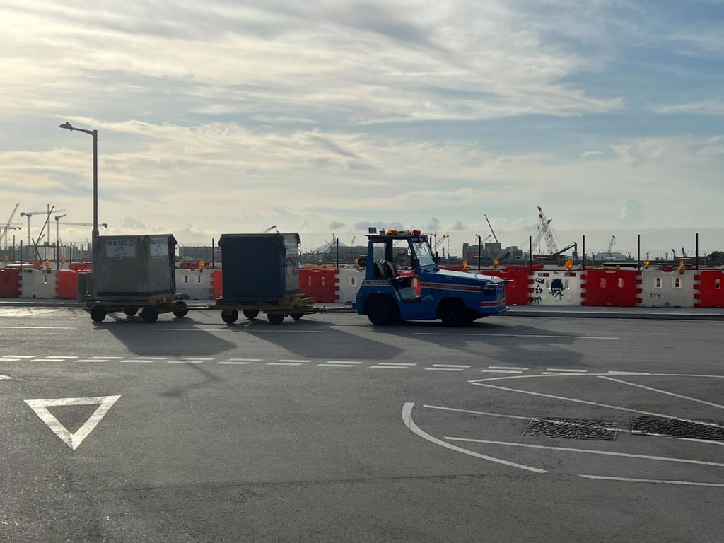 A Uisee autonomous electric tractor transports baggage to SkyPier Terminal at HKIA.
