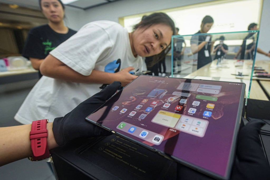 A visitor checks out the fully opened display of the Mate XT, Huawei Technologies’ new tri-fold smartphone, at a Huawei store in Hangzhou, capital of eastern Zhejiang province, on Tuesday. Photo: AFP