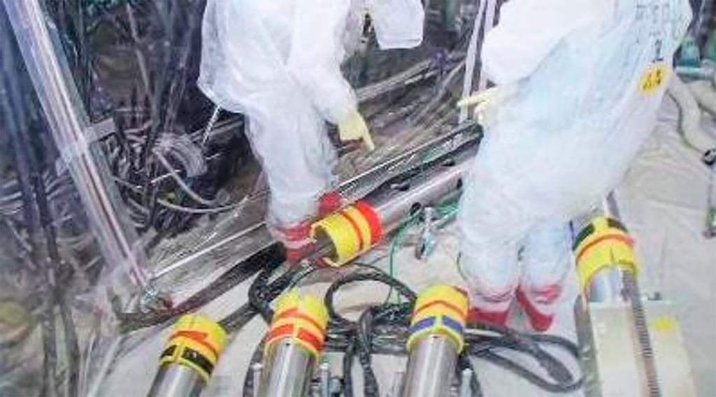 Tepco workers rearrange pipes for the recovery mission at Fukushima Daiichi nuclear power plant. Photo: Tepco via AP Tepco workers rearrange pipes for the recovery mission at Fukushima Daiichi nuclear power plant. Photo: Tepco via AP