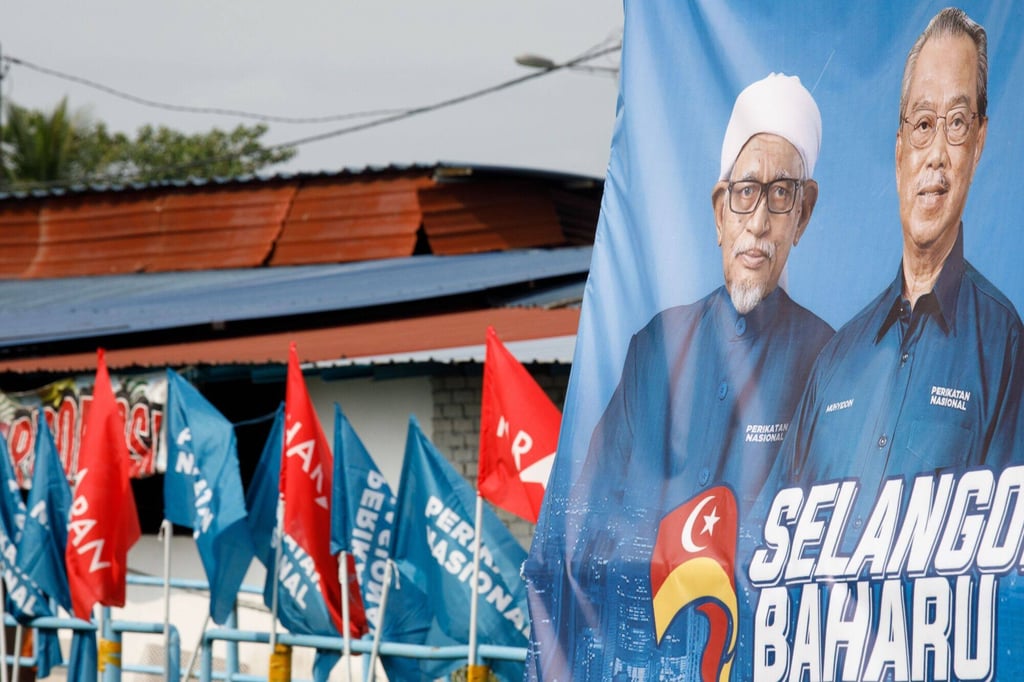 A poster featuring Perikatan Nasional leader Muhyiddin Yassin and PAS leader Hadi Abdul Awang near a polling station in Selangor during state elections last year. Photo: Bloomberg A poster featuring Perikatan Nasional leader Muhyiddin Yassin and PAS leader Hadi Abdul Awang near a polling station in Selangor during state elections last year. Photo: Bloomberg