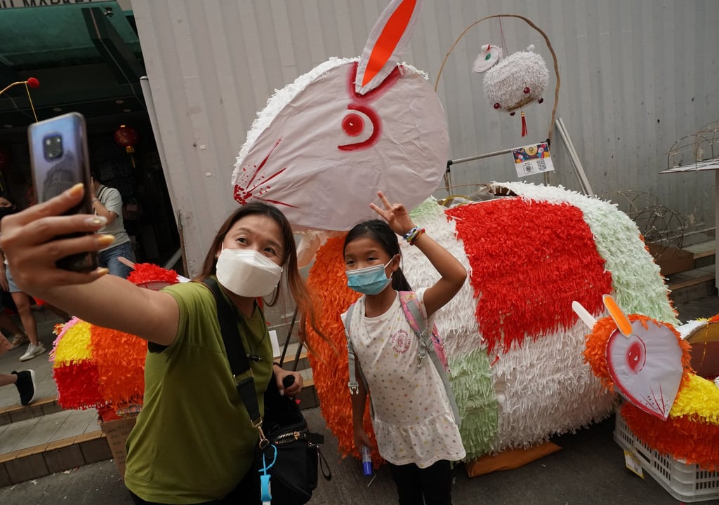 Two people take a selfie in front of a giant white rabbit lantern at Tai Kiu Market in Yuen Long, Hong Kong, ahead of Mid-Autumn Festival celebrations, on September 12, 2021. Photo: Felix Wong