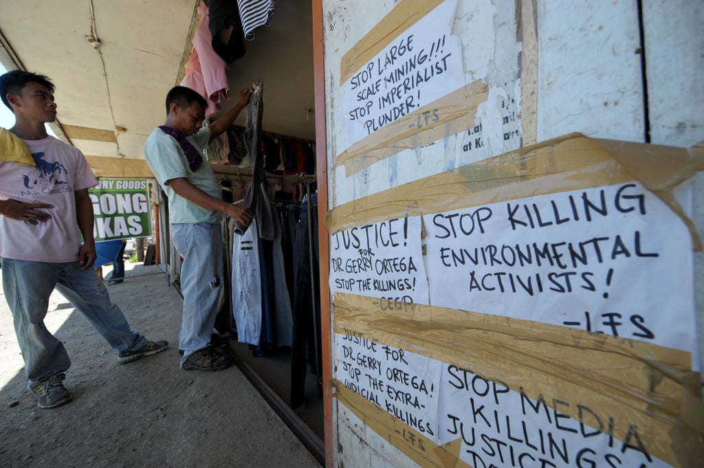 Banners with messages seeking justice and against large scale mining posted at the second-hand clothing shop where environment activist Gerry Ortega was shot in Palawan’s capital, Puerto Princesa. Photo: AFP