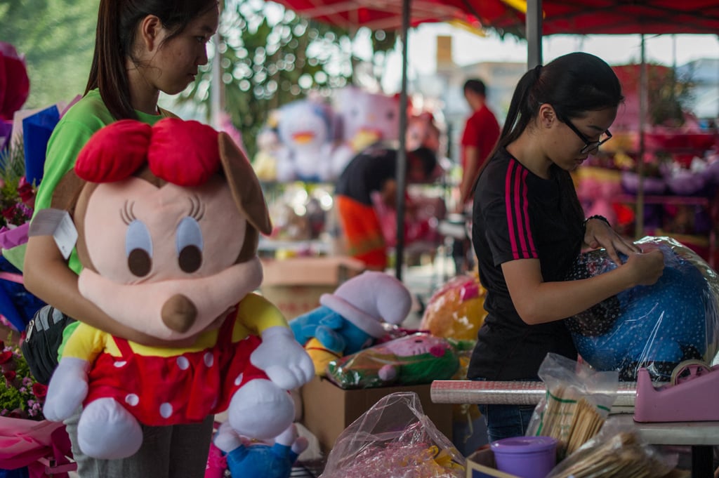 Workers arrange stuffed toys for sale in Kuala Lumpur. E-commerce platforms are often much more affordable than regular shops. Photo: AFP