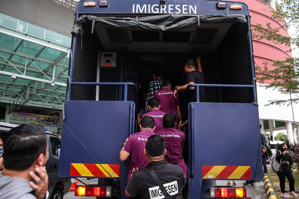 Immigration officers detain migrants who have overstayed their visas during a raid in Klang, Malaysia, on August 15. Photo: EPA-EFE