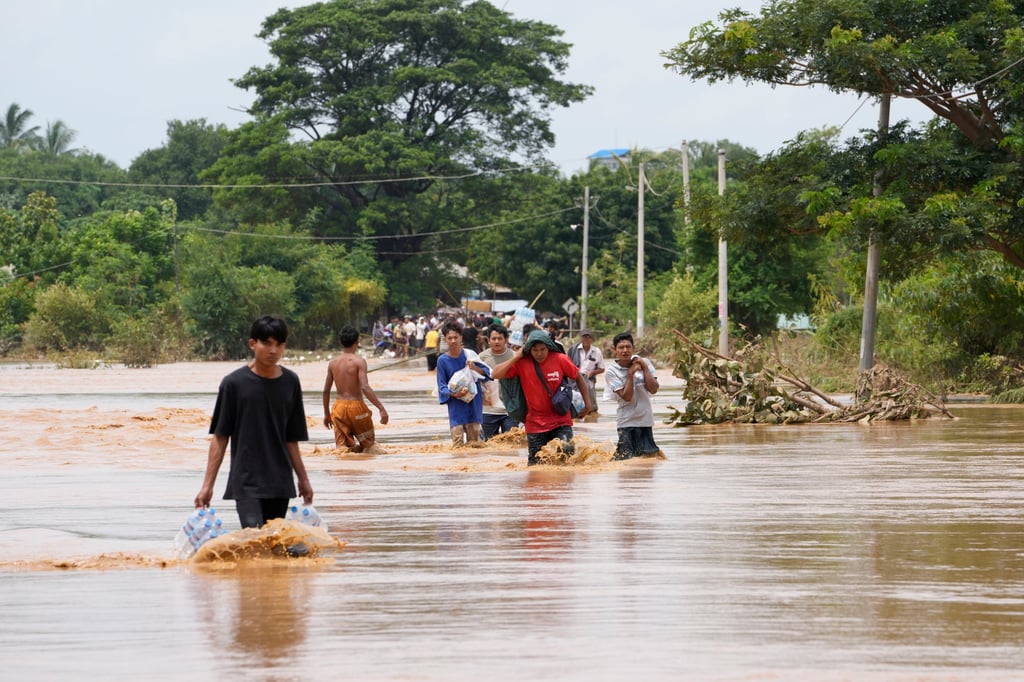 Residents wade through a flooded road in Naypyitaw, Myanmar. Photo: AP Residents wade through a flooded road in Naypyitaw, Myanmar. Photo: AP